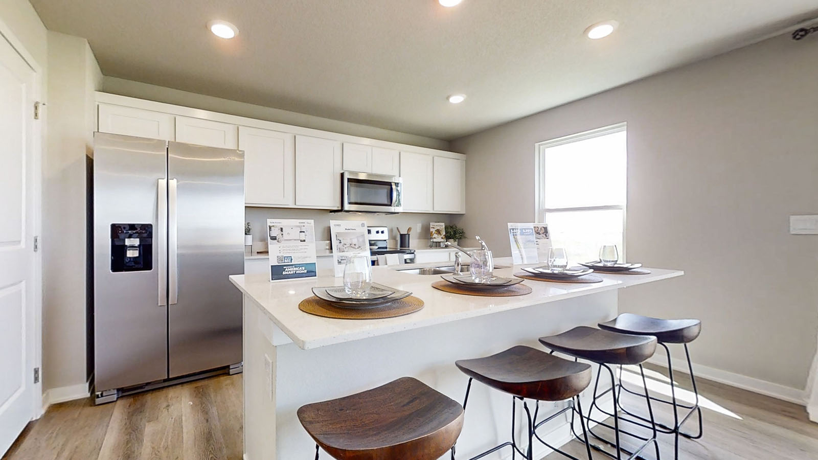 Bellhaven kitchen with island 4 stools white cabinets and stainless steel appliances