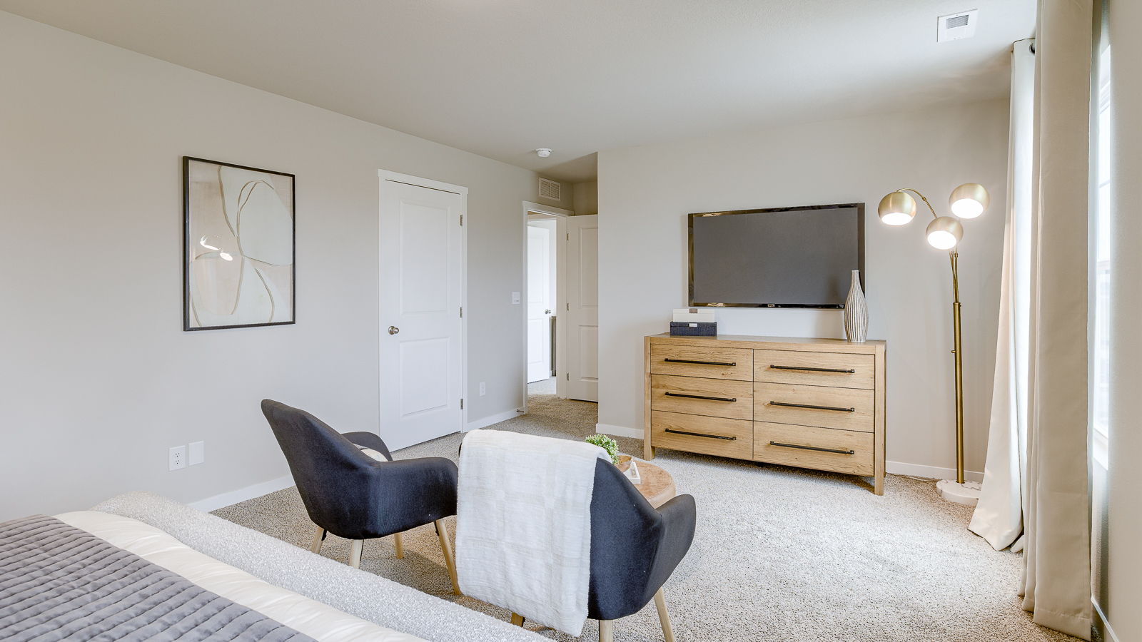 Primary bedroom in the Bellhaven showing seating area and primary closet
