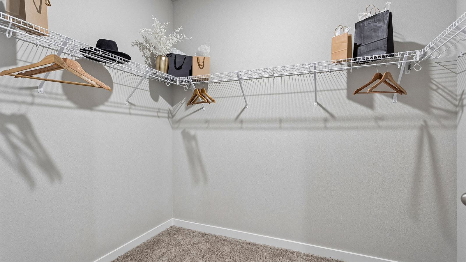 Neuville primary walk-in closet with hangers and shopping bags