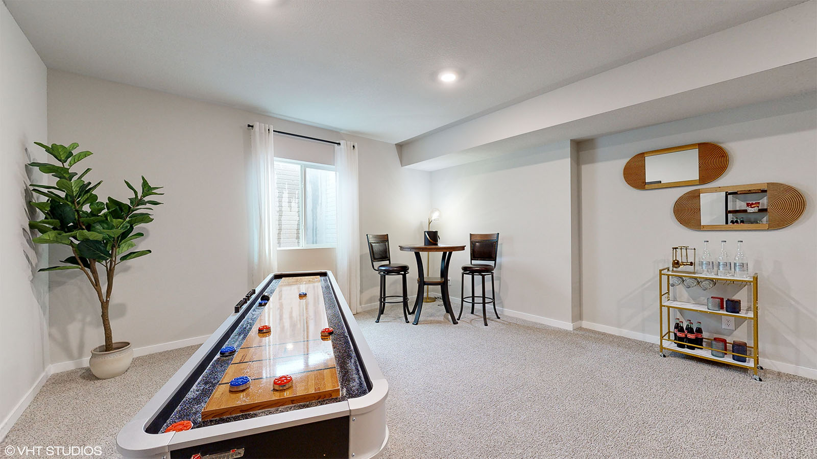 Finished basement family room in the Fairfield with a shuffle board table and high bar table