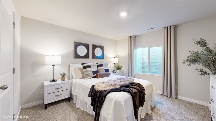 Fourth bedroom in the finished Abbott basement with white queen bed