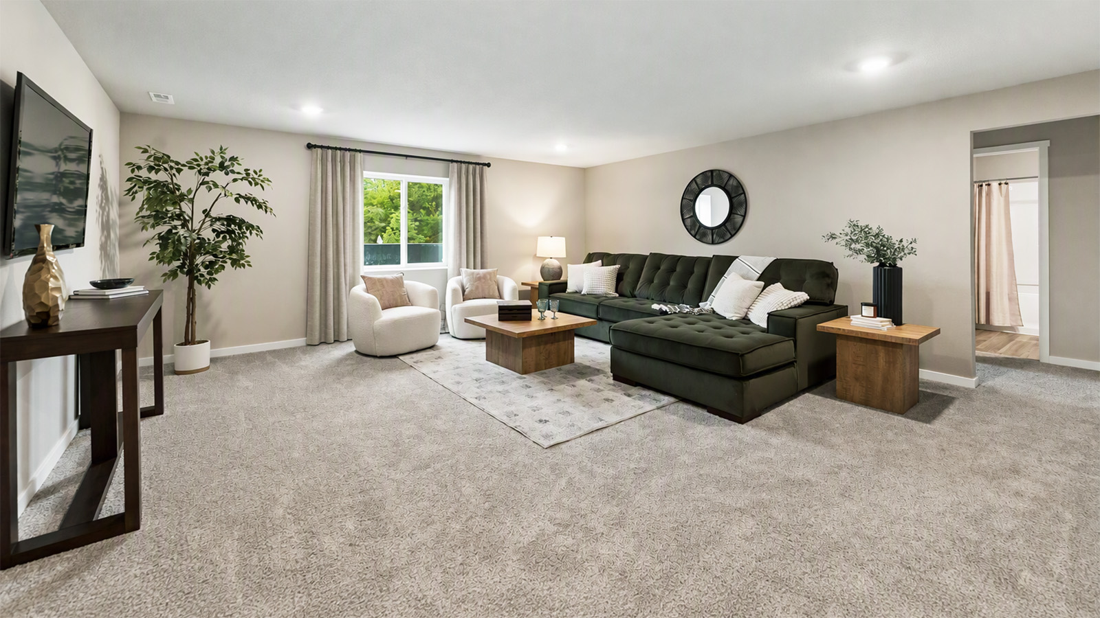 Bright finished basement living room in the Hamilton with sectional couch and chairs
