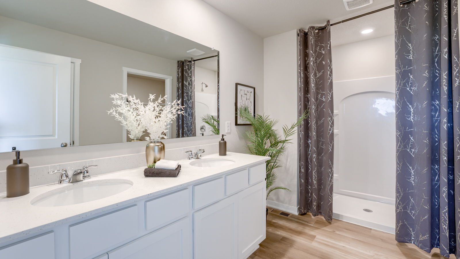 Neuville primary bathroom with dual sinks and a walk-in shower