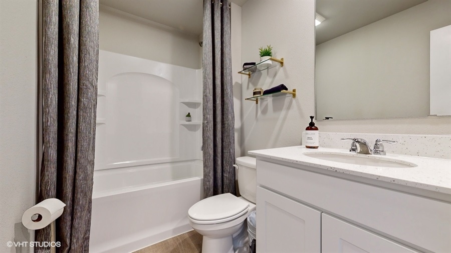 Second full bathroom in the Neuville with a sink toilet and bathtub