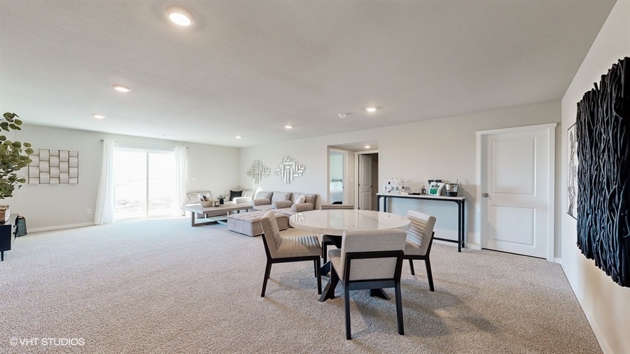 Finished basement living room in the Neuville with a seating area and table with 4 chairs