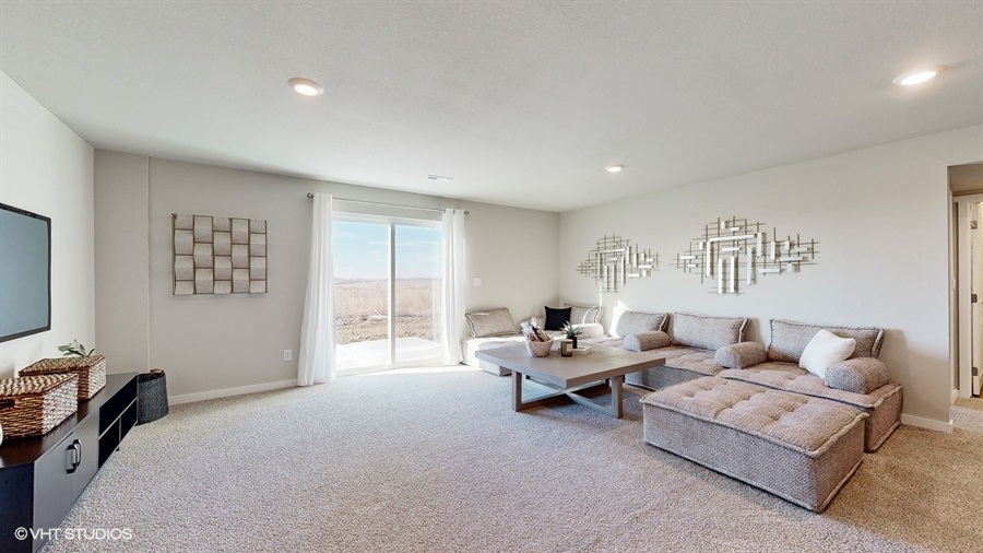Neuville finished basement living room with a large sectional and sliding glass door walkout
