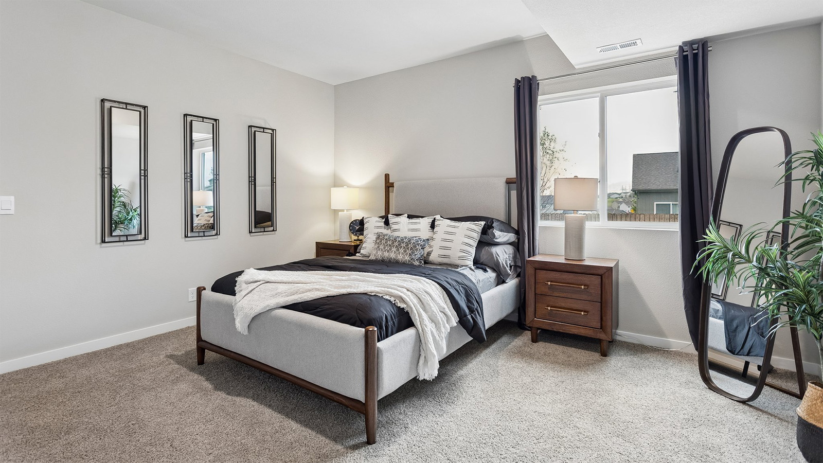 Fourth bedroom in the Neuville finished basement with large window and queen bed