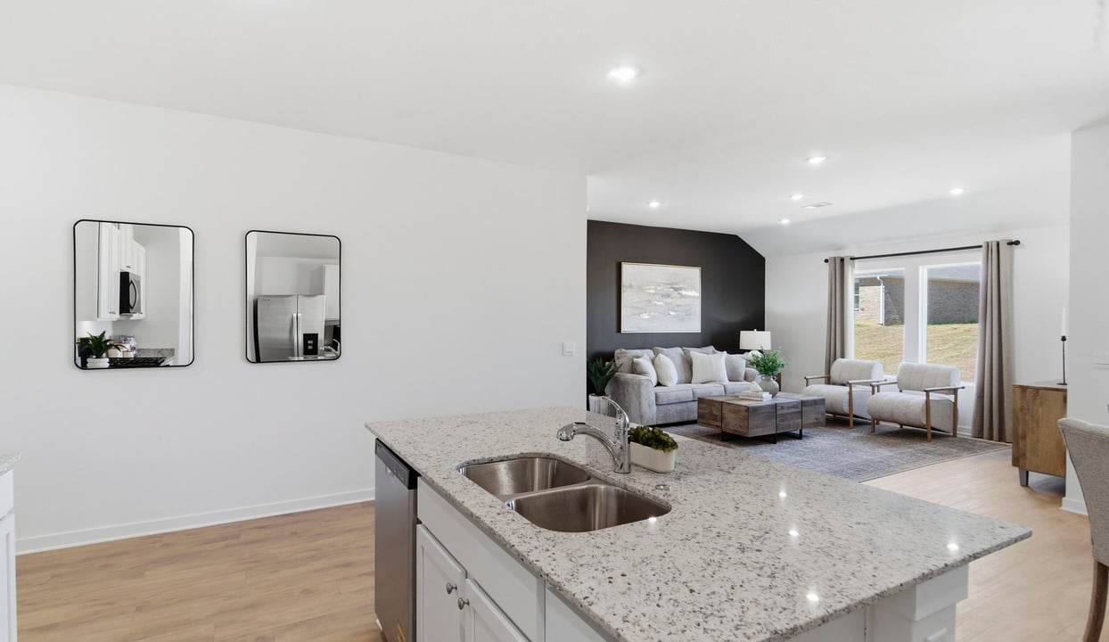Contemporary kitchen island adorned with white cabinets seamlessly integrated into an open dining area layout.