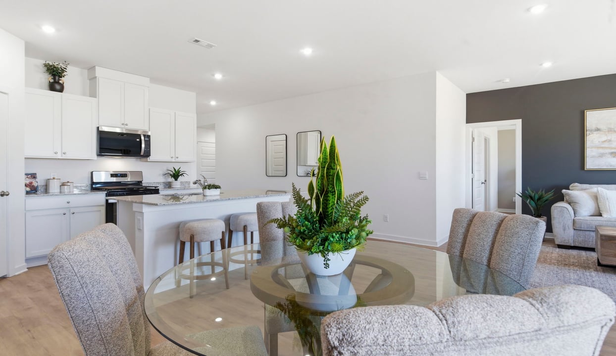 Spacious dining area with vinyl wood flooring, large window and tall ceiling.