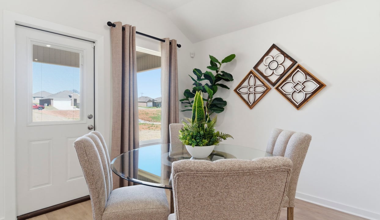 Formal dining room with large windows, vinyl wood floors, and view of the backyard.