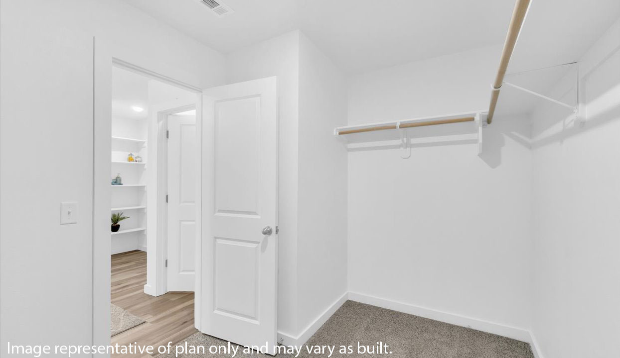 Spacious master closet with white walls and shelving