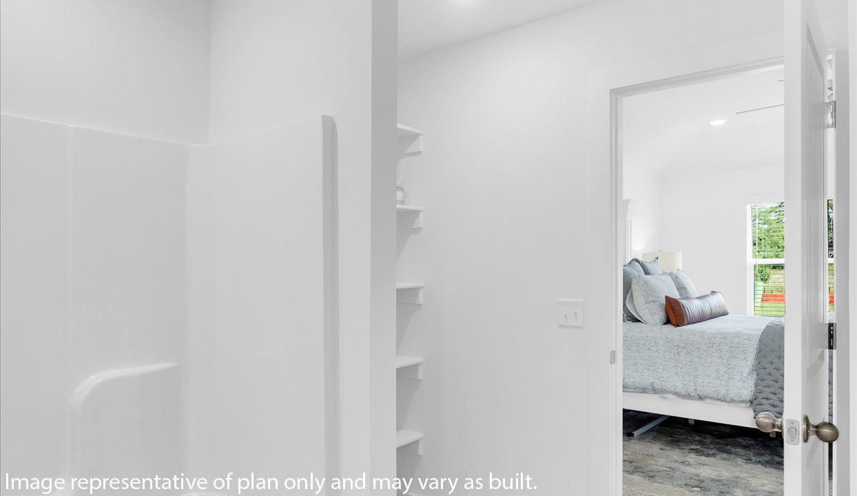 Master bathroom featuring a shower/tub combo with built in shelves. Door leading into the master bedroom.