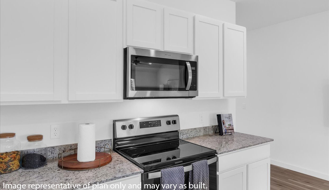 Kitchen area with white cabinets and stainless steel appliances.
