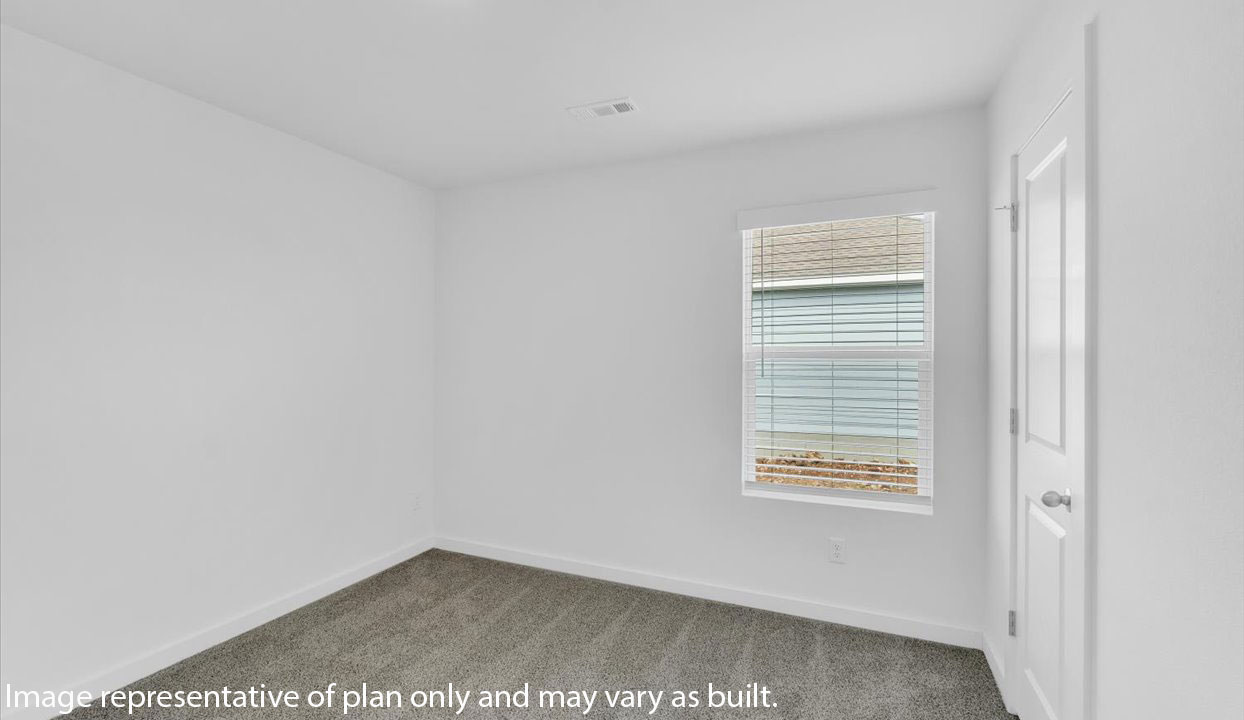 Bedroom with white walls, window, and gray carpet . Door leading into closet.