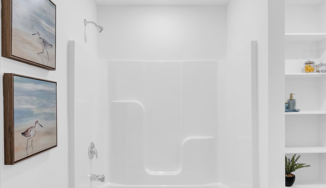 Master bathroom featuring a shower/tub combo with built in shelves