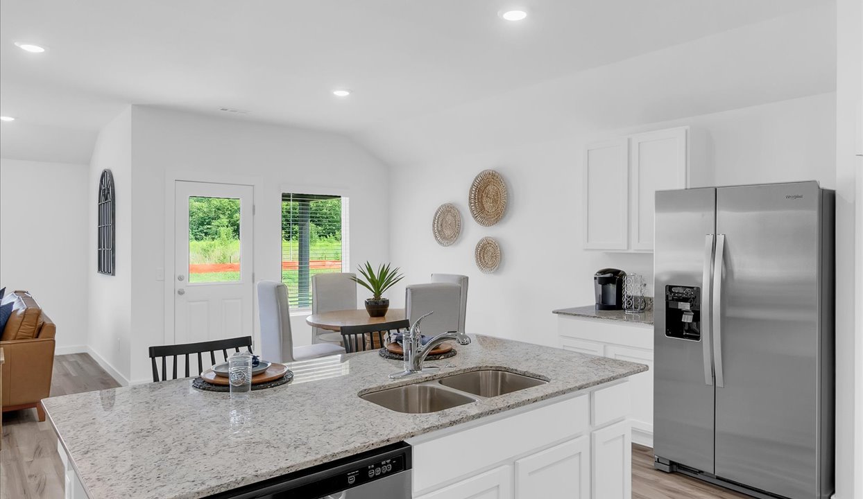 Modern open-concept living and kitchen peninsula with white cabinets and stainless steel appliances.