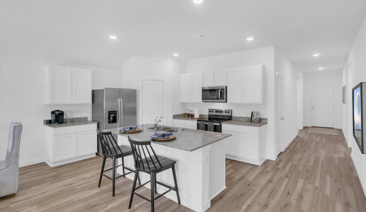 Modern open-concept  kitchen with peninsula that has white cabinets and stainless steel appliances.