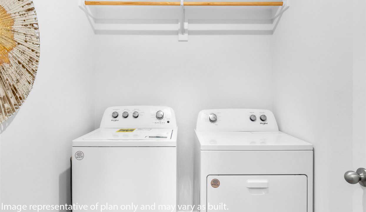 Laundry room with white cabins and washer/dryer unit.