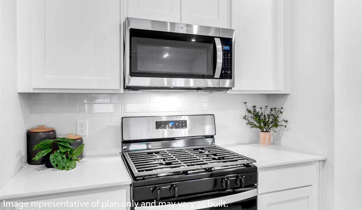 Kitchen counter top with white backsplash and stainless steel appliances.