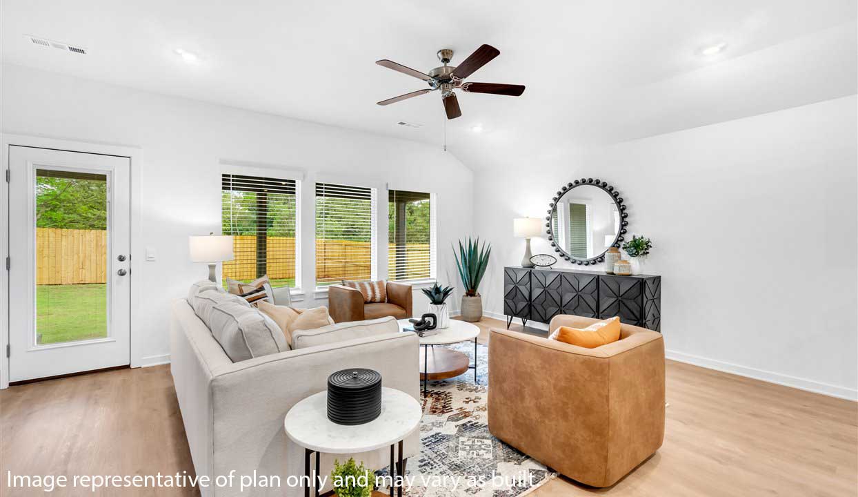 Living room area featuring white walls, light colored floors with three large windows. Back door leading to patio area.