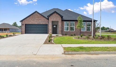 Single-story home with red brick exterior siding with a walk-up sidewalk