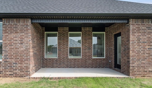 Outdoor Patio with red brick exterior, large windows, and spacious yard.