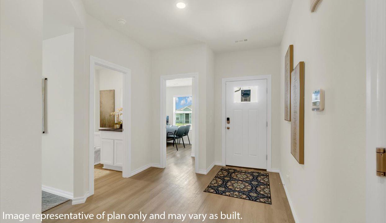 A bright hallway with abstract wall art and light wood flooring leads to a living area, with a home office visible on the right.