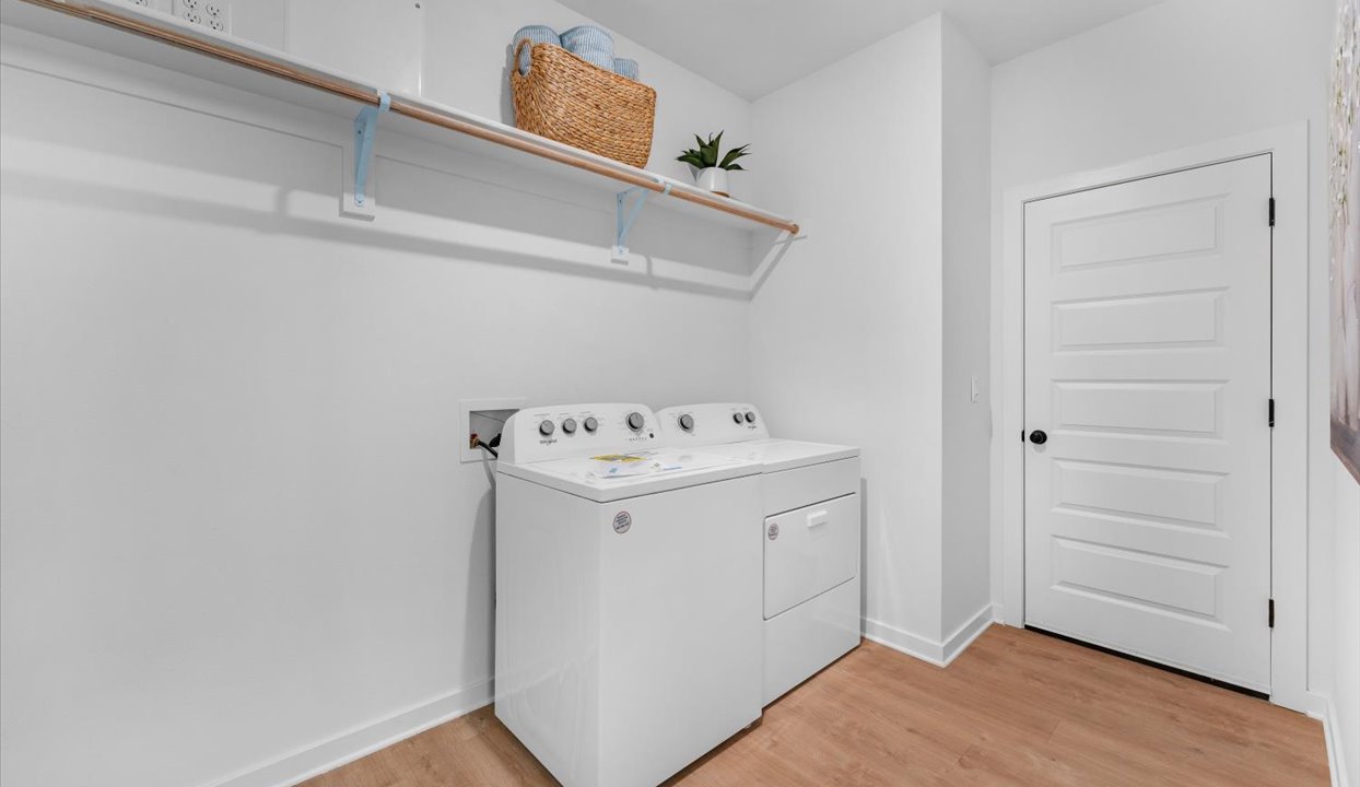 Laundry room with white shelf above washer/dryer unit.