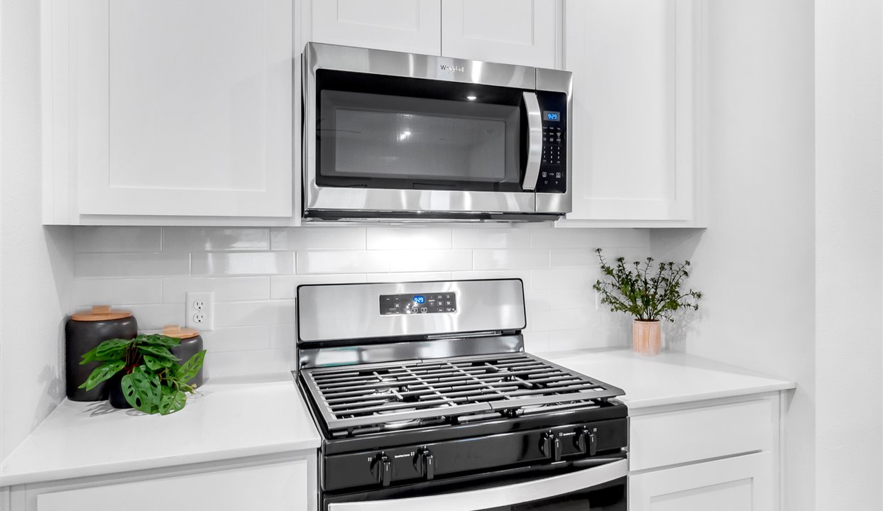 Kitchen counter top with white backsplash and stainless steel appliances.