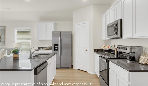 Modern open-concept living and kitchen peninsula with white cabinets and stainless steel appliances.