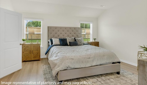Primary Bedroom with white walls featuring large bed and nightstands. Doorway into the master bathroom.
