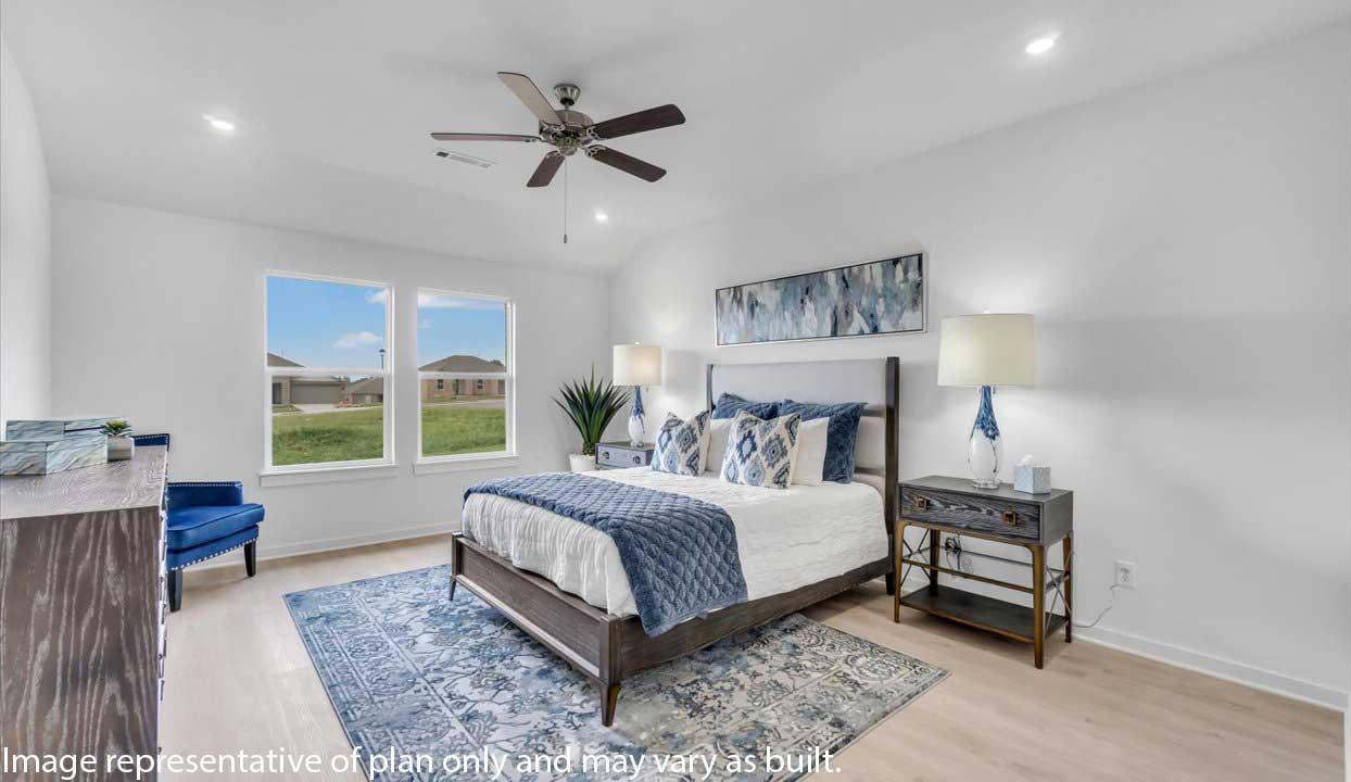 Spacious bedroom with a dark wood bed frame, white and blue bedding, and large windows. Decor includes a blue accent chair, abstract wall art, bedside lamps, and a patterned area rug.