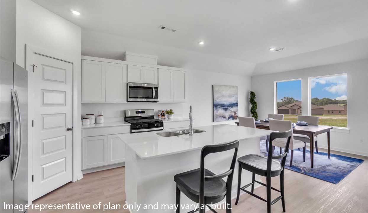 Bright kitchen with white cabinets, island seating, and adjoining dining area with large windows.