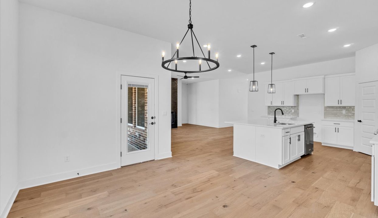Kitchen peninsula with white cabinets and stainless steel appliances