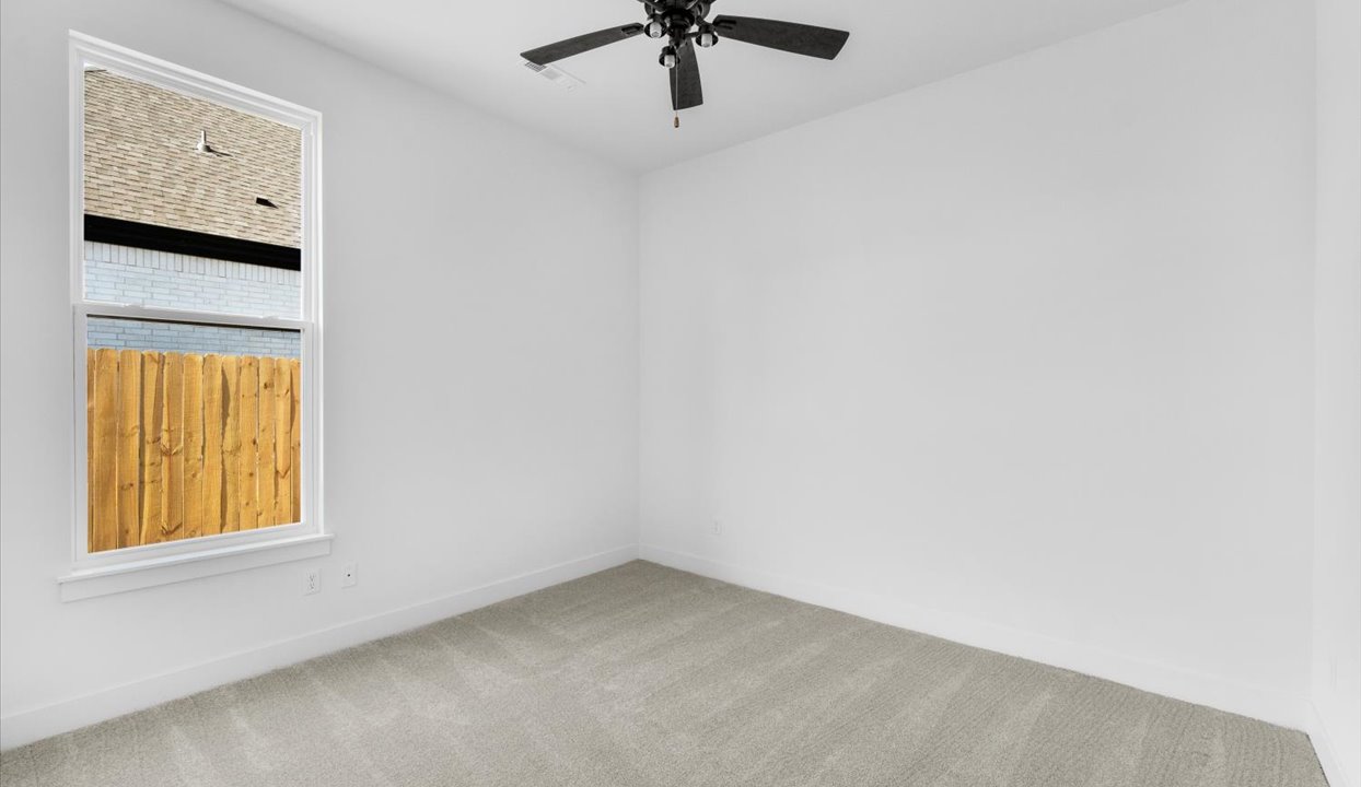 Bedroom with white walls, window and ceiling fan.