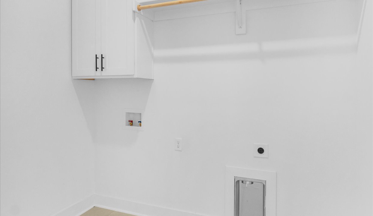 White laundry room with shelving.