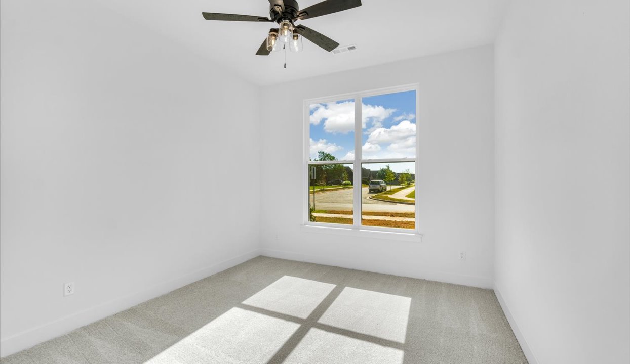 Bedroom with white walls, window and ceiling fan.