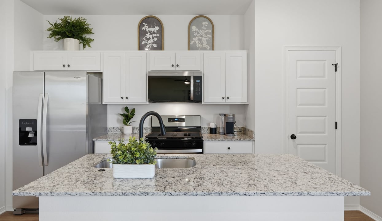Contemporary kitchen adorned with white cabinets seamlessly integrated into an open dining area layout.