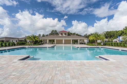 Sunny day at the community swimming pool with lounge seating.