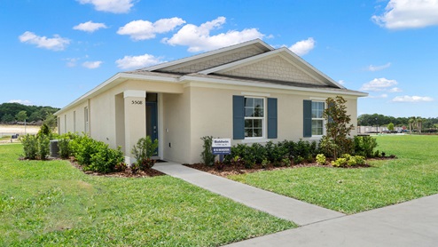 Single story new home with large windows, and grassy front yard.