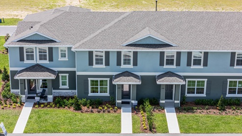 Two story Attached townhome with concrete block construction and a one-car garage.