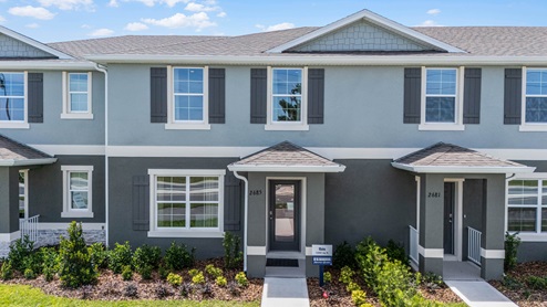 Two story Attached townhome with concrete block construction and a one-car garage.