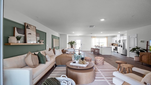 Living area with couch seating overseeing kitchen and dining room..