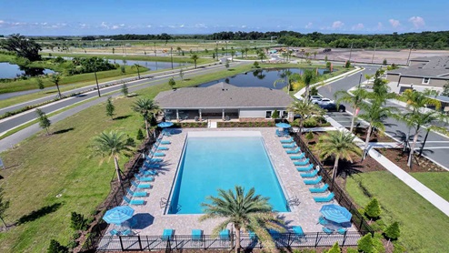 Arial shot of community swimming pool with lounge seating.
