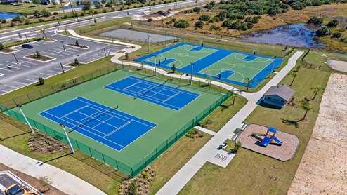 Arial show of double outdoor basketball court and double tennis court amenity.