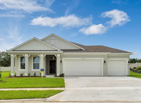 Single story new home with driveway, large windows, and grassy front yard and 2-car garage