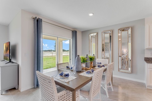 Dining room adjacent to the kitchen with table, chairs and tile flooring.