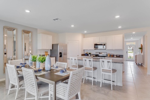 Dining room adjacent to the kitchen with table, chairs and tile flooring.