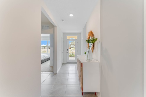 Home entry way facing the front door with tile flooring.