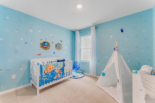 Child's nursery with crib, closet, soft seating and storage.